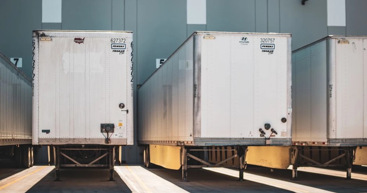 A row of freight trailers parked at a commercial loading dock, emphasizing transportation and logistics.